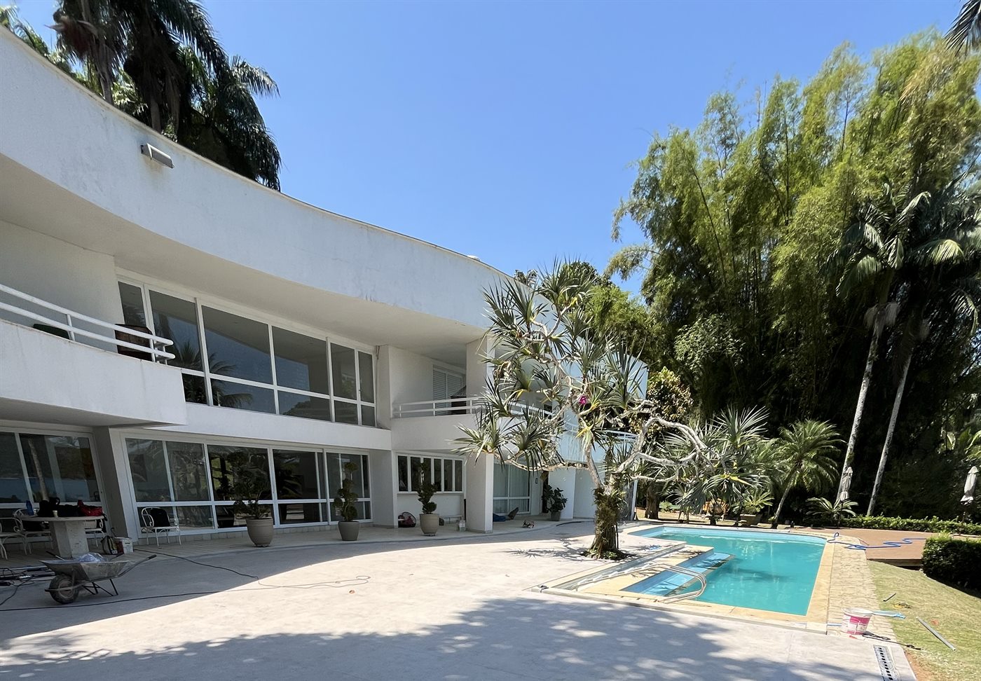 Área externa reformada de residência na Vila Velha com piscina, piso claro e fachada branca